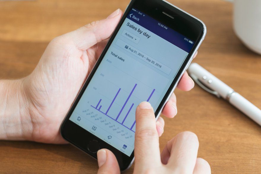 Person looking at their Shopify sales dashboard on cell phone