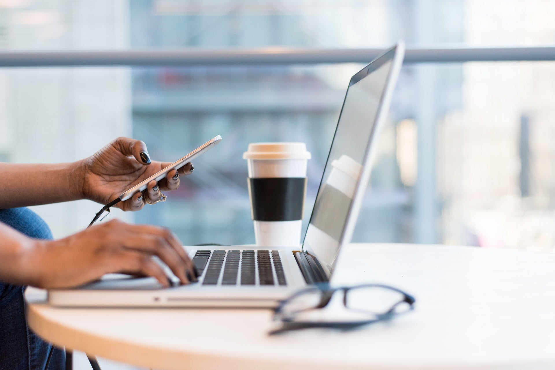 Person working on their phone and laptop in an office