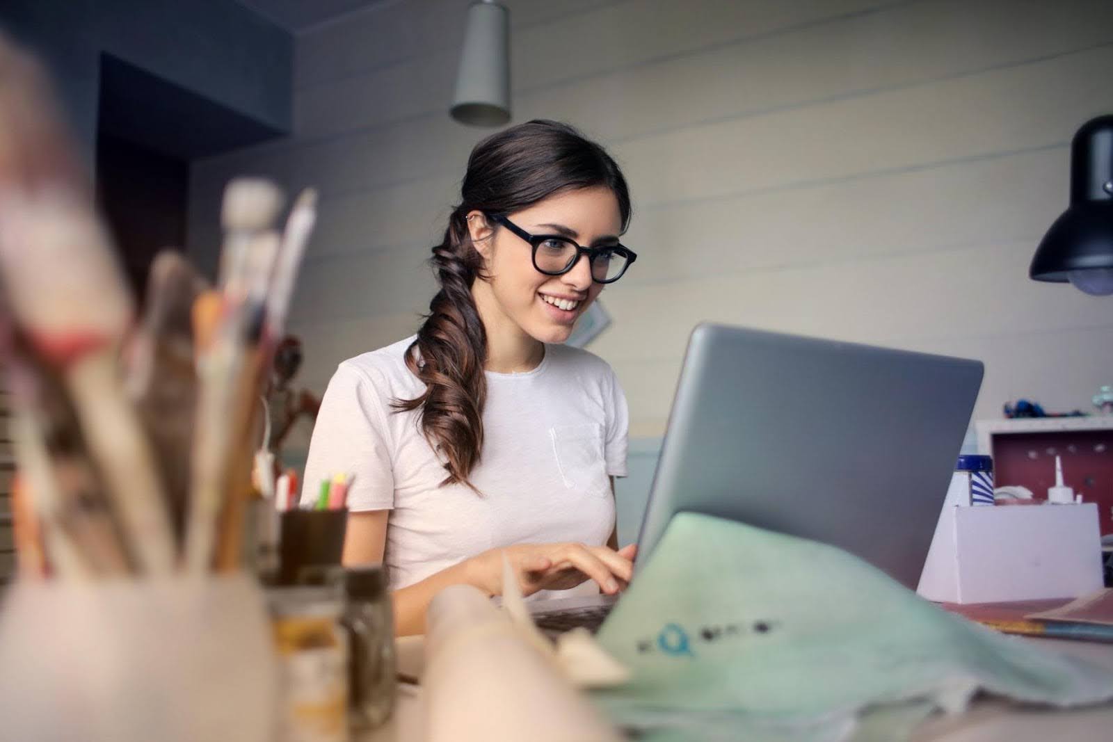 woman with glasses working on laptop 